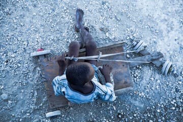 Haitian youth showcasing local ingenuity with handcrafted cart